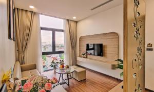 a living room with a couch a table and a tv at MAI Luxury Hotel Ninh Binh in Ninh Binh