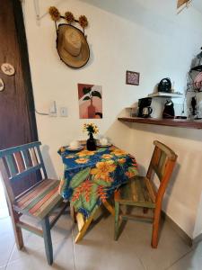 un tavolo e due sedie con tavolo e tavolo di Apartamento Perequê Lá da Ilha a Ilhabela