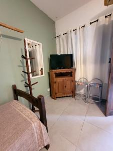 una camera con TV, letto e specchio di Apartamento Perequê Lá da Ilha a Ilhabela Altre 12 foto