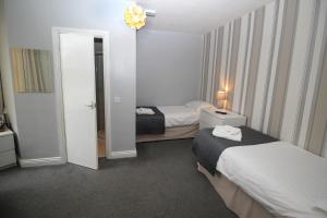 a hotel room with two beds and a mirror at The Sefton Hotel in Bridlington