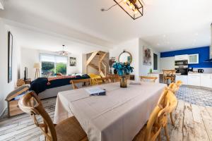 a dining room and living room with a table and chairs at Villa avec piscine privée, sauna, jardin et parking in Barneville-Carteret
