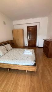 a bedroom with a bed and a wooden floor at Quarto com varanda no centro de viseu in Viseu