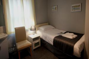 a small bedroom with a bed and a chair at The Sefton Hotel in Bridlington