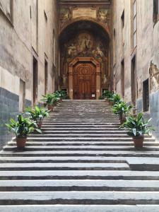 a staircase leading to a wooden door in a building at San Gregorio Suite&Rooms in Naples +38 photos