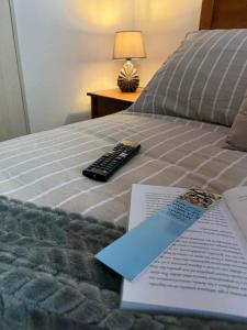 a remote control sitting on top of a bed at Moderno Dpto Vista al Mar y Piscina Temperada in La Serena