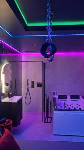 een kamer met paarse en groene lichten en een badkamer bij Love room - Xtase By luxuria Cannes in Cannes