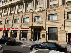 a large building with cars parked in front of it at Smith Hotel in Baku