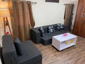 a living room with a couch and a table at Cloudscape Cottage in Shimla