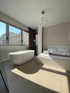 a large bathroom with a tub and a bed at Orchidea suites - City center in Bari