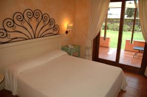 sypialnia z białym łóżkiem i dużym oknem w obiekcie Lantana Resort Hotel&Apartments w Puli