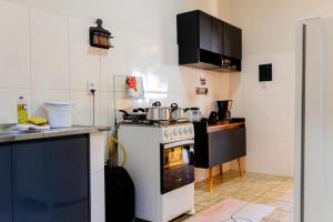 a kitchen with a white stove top oven next to a counter at Casa Alegria piscina churrasqueira in Montes Claros