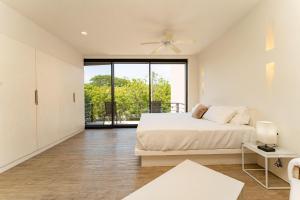 Un dormitorio blanco con una cama y un balcón. en 3013 - Mixie 305, en Santa Cruz Huatulco 32 fotos más
