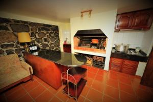 a kitchen with a counter and a stone oven at Casa da Portada in São Vicente