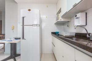 cocina blanca con nevera y fregadero en CF · Cabo Frio Relax!, en Cabo Frío