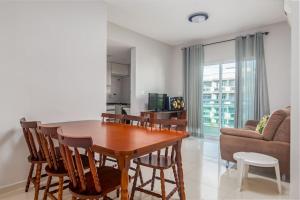 Una sala de estar con una mesa y sillas de madera. en CF · Cabo Frio Relax!, en Cabo Frío 19 fotos más