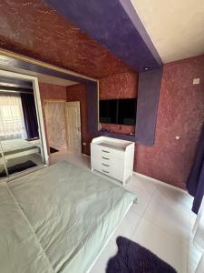 a bedroom with a bed and a dresser in it at LADA Apartment in Nesebar