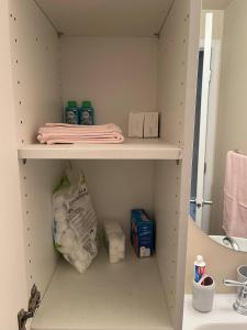 une armoire avec des serviettes et des articles de toilette dans la salle de bains. dans l'établissement Tranquille pond facing suite, à Nisku