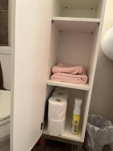 un placard avec des serviettes et du papier toilette sur une étagère. dans l'établissement Tranquille pond facing suite, à Nisku 68 autres photos