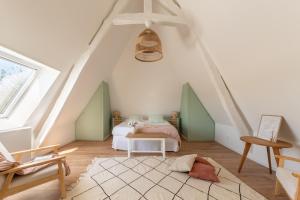 a attic bedroom with a bed and a table at Sublime Longère Le Garden, 10 voyageurs, 2 terrasses, terrain de Basket in Triqueville