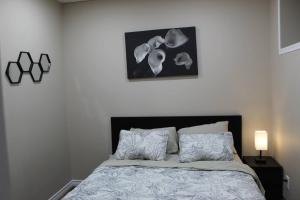 - une chambre avec un lit et une photo au-dessus dans l'établissement Tranquille pond facing suite, à Nisku