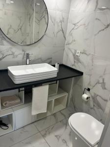a white bathroom with a sink and a mirror at Duplex no estoril in Estoril