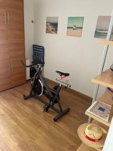 a room with a exercise bike and a chair at Duplex no estoril in Estoril