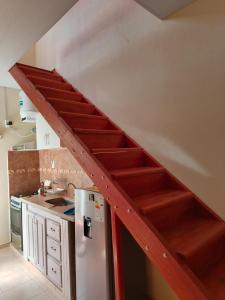 a staircase in a kitchen with a stainless steel refrigerator at La Palmera in Chajarí