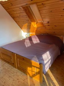 a bed in a room with a wooden ceiling at Dom nad samym Bugiem 2h od Warszawy in Klepaczew