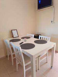 a white table with four chairs and a tv at La Palmera in Chajarí