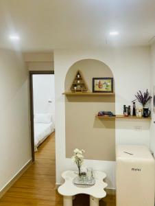 ein Raum mit einem Tisch mit Blumen darauf in der Unterkunft Love House - Căn hộ 2 phòng ngủ tại Nera Garden Huế in Thôn Văn Dương
