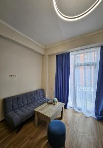 a living room with a blue couch and a table at Alvina complex in Tsaghkadzor +6 photos