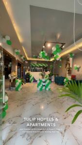 a lobby with a lot of green balloons and decorations at Tulip Hotel in Karachi