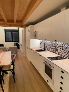 a kitchen with white cabinets and a table and chairs at Hotel Apartamento Los Villares in Los Villares de Soria