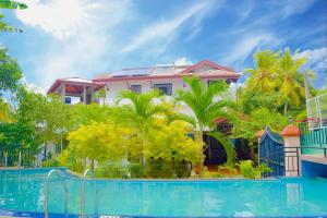 NakandalagodaVilla Acadia Bentota的有游泳池和棕榈树的度假村