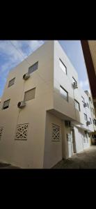 a white building with windows on the side of it at Modern Neubau Apartment 3 Klima WLAN Beach in M'diq