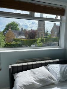 a bed in a bedroom with a large window at The Dunkirk Avenue Nest in Desborough