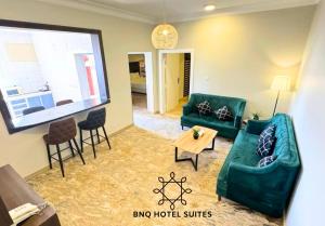 a living room with two green couches and a table at البندقية للخدمات الفندقية BQ HOTEL SUITES in Buraydah
