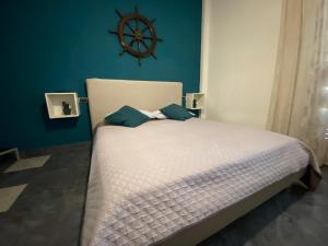 a bedroom with a white bed with a blue wall at La dimora del marinero in San Benedetto del Tronto