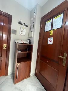 a wooden door in a room with a desk at SkyRest Bollullos in Bollullos de la Mitación