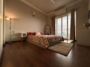 a bedroom with a bed and a large window at Valley of us in Sohna +71 photos