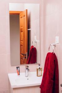 a bathroom with a sink and a mirror and red towels at Peaceful Nest Apartment in Kigali