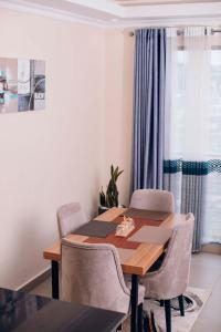 a dining room with a wooden table and chairs at Peaceful Nest Apartment in Kigali
