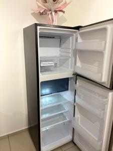 an empty refrigerator with its door open in a kitchen at Taman Equine comfy studio, high-end facilities in Seri Kembangan