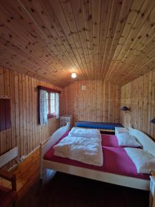 a large bed in a room with a wooden ceiling at Hov Hyttegrend in Viksdalen