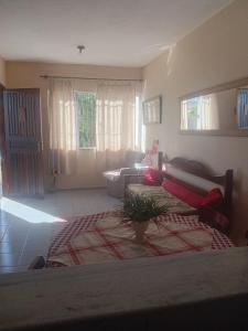 a living room with a bed and a couch at Casa de temporada piscina com proxima a praia in Saquarema