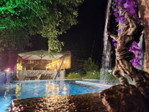 a fountain in the middle of a pool at night at Erdem Ciftligi/ Ephesus Arena in Selçuk +66 photos