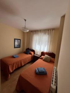 a room with two beds and a window at La casita de carmen in Cazorla