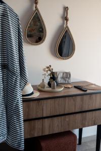 a wooden dresser with two mirrors on the wall at Petres Luxury Villas with heated private pool in Agia Galini