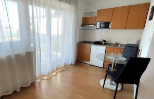 een kleine keuken met een tafel en een tafel met stoelen bij Amélie Apartments in Poreč +7 foto's