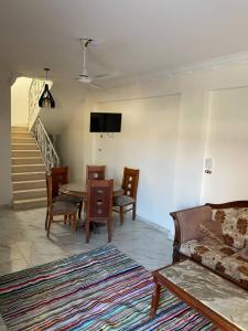 a living room with a couch and a table and chairs at ڤيلا في الساحل الشمالي in Borg El Arab
